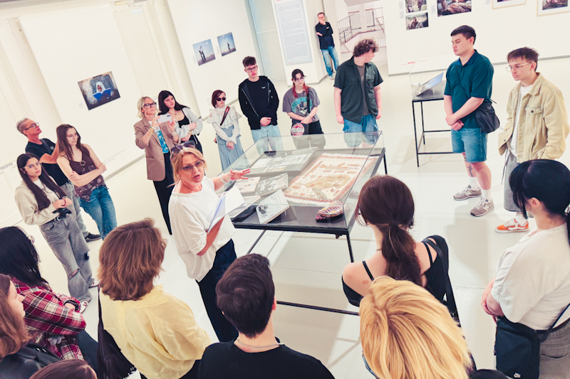 Führung an einer Vitrine mit Dokumenten und Materialien aus dem Werk von Anja Niedringhaus