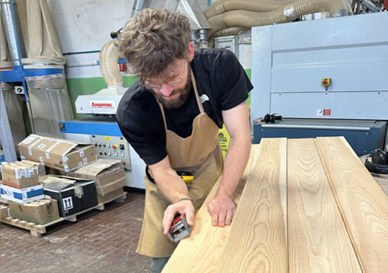 Eine Person hobelt eine Holzbrett