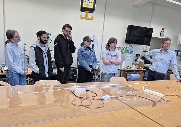 Schülerinnen und Schüler am Arbeitstisch mit Arbeitsmaterialien