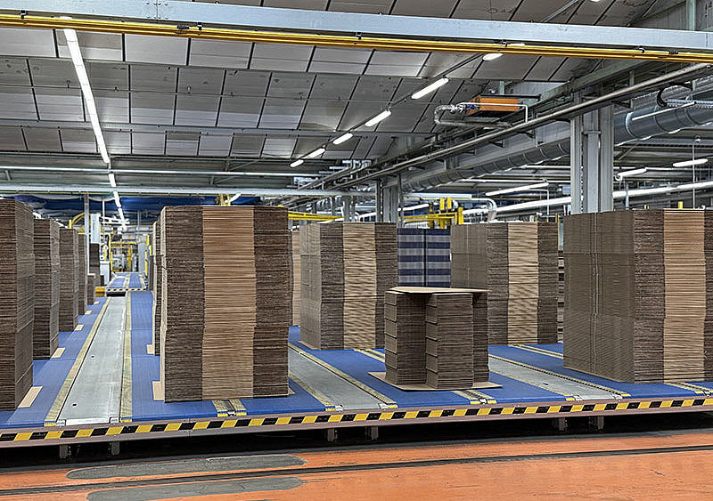 Transportsystem mit flachgelegten Faltschachteln im Lager