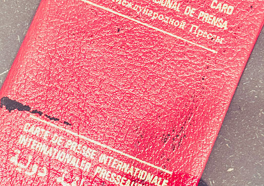 Detailaufnahme eines roten internationalen Presseausweises mit Gebrauchsspuren