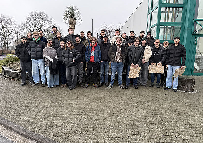 Gruppenbild vor dem Eingang draußen.