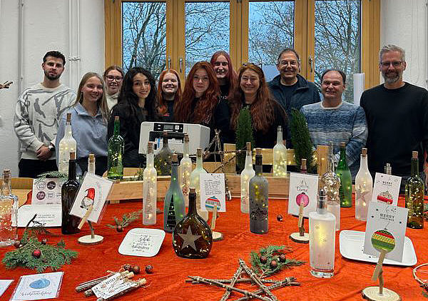 Gruppenbild vor rotem Tisch und Dekoration