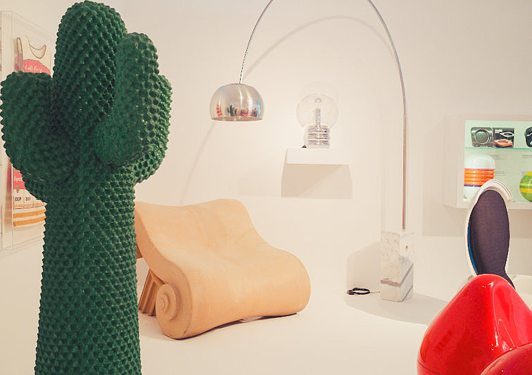 Detailansicht einer Designausstellung im Museum für Angewandte Kunst Köln mit einer grünen kaktusförmigen Skulptur, modernen Sitzmöbeln und Lampen.